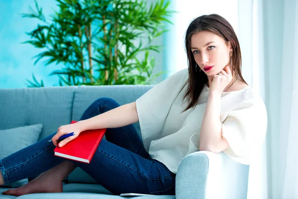 Dreaming girl with pen writing on notebook — Stock Photo, Image