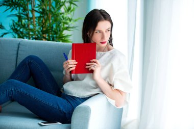 evde kırmızı bir not kitabı ile kız