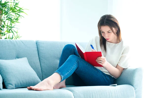 Young brunette girl is making selfie at sofa — Stock Photo, Image