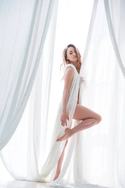 Menina loira bonita posando em pano branco. Sensualidade e beleza das mulheres — Fotografia de Stock