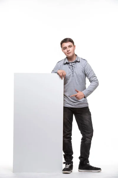 Primo piano dell'uomo che mostra la lavagna bianca. Ragazzo adolescente, studente, scolaro mostrando spazio vuoto cartello bianco — Foto Stock
