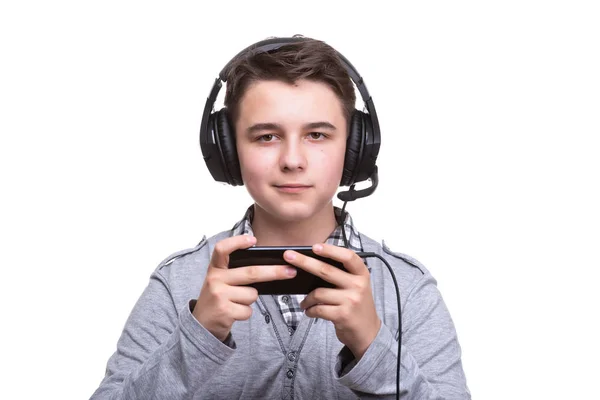 School jongen Guy tiener met koptelefoon spelen een spel op mobiele telefoon. Gokken, telefoonverslaving — Stockfoto