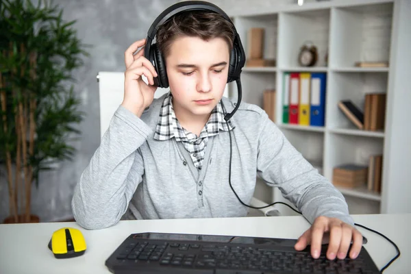 Oops, failure, loss. Teenager boy lost in a computer game. A schoolboy sits upset in front of a computer monitor, covering his face with his hands — Stock Photo, Image