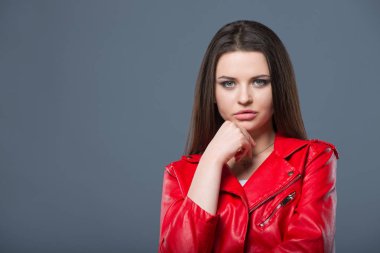 Şık tarzı, moda kadın giyim, renk kombinasyonu. Beyaz elbise ve kırmızı deri ceket izole gri arka planda güzel esmer kız