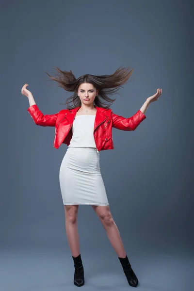 Estilo de moda, ropa de mujer de moda, combinación de colores. Hermosa chica morena en vestido blanco y chaqueta de cuero rojo. Cabello volador — Foto de Stock