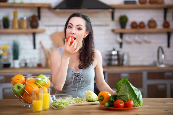 A hungry woman takes her hands and eats vegetables, stuffing them in her mouth. Healthy food