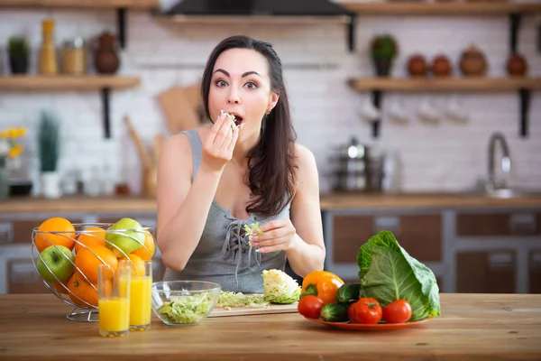 배고픈 여자는 그녀의 손을 잡고 야채를 먹고, 그녀의 입에 그들을 채우기. 건강한 음식 — 스톡 사진