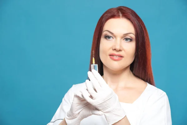 Piękna kobieta lekarz kosmetolog trzymając strzykawkę z roztworem do zastrzyków kosmetycznych. na białym tle żeński portret Studio — Zdjęcie stockowe