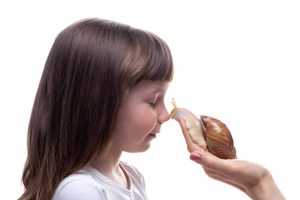 Attraktives kleines Mädchen hält eine Akhatina-Schnecke. isoliert auf weißem Hintergrund. Nahaufnahme. Konzept der Jugend- und Schönheitshaut, Gesichtsverjüngung — Stockfoto