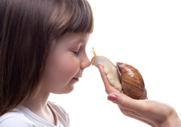 Attraktives kleines Mädchen hält eine Akhatina-Schnecke. isoliert auf weißem Hintergrund. Nahaufnahme. Konzept der Jugend- und Schönheitshaut, Gesichtsverjüngung — Stockfoto