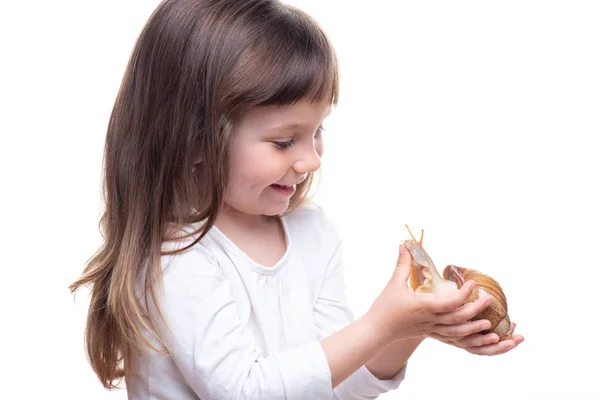 Une jolie petite fille tient un escargot Akhatina. Isolé sur fond blanc. Ferme là. Concept de peau de jeunesse et de beauté, rajeunissement facial — Photo