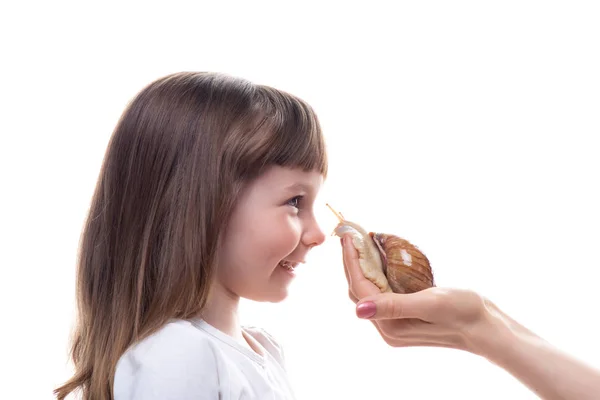 Attraktives kleines Mädchen hält eine Akhatina-Schnecke. isoliert auf weißem Hintergrund. Nahaufnahme. Konzept der Jugend- und Schönheitshaut, Gesichtsverjüngung — Stockfoto