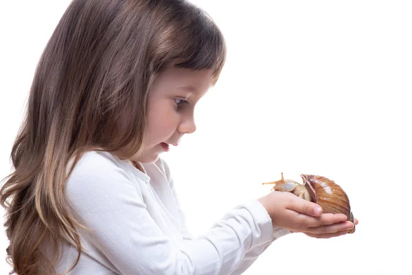 Attraktives kleines Mädchen hält eine Akhatina-Schnecke. isoliert auf weißem Hintergrund. Nahaufnahme. Konzept der Jugend- und Schönheitshaut, Gesichtsverjüngung — Stockfoto