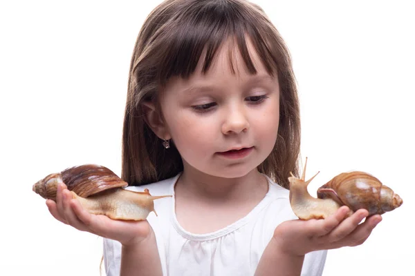 Attraktives kleines Mädchen hält eine Akhatina-Schnecke. isoliert auf weißem Hintergrund. Nahaufnahme. Konzept der Jugend- und Schönheitshaut, Gesichtsverjüngung — Stockfoto