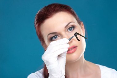 Kadın doktoru tıbbi sülükler cımbız tutar. Hirudotherapy, H