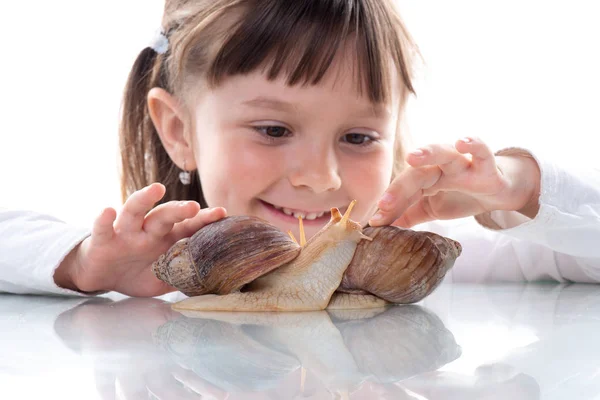 Niedliches kleines Mädchen und Akhatina Schnecke. Nahaufnahme. Haustiere. Konzept der Jugend- und Schönheitshaut, Gesichtsverjüngung — Stockfoto