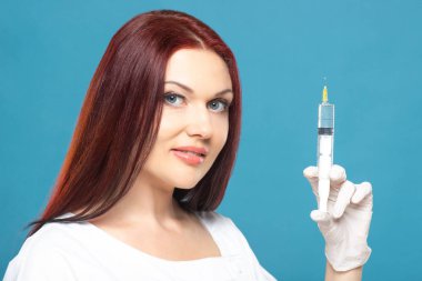 Güzellik enjeksiyonları için çözüm ile şırınga tutan güzel kadın doktor Kozmetolog. izole kadın portre stüdyo
