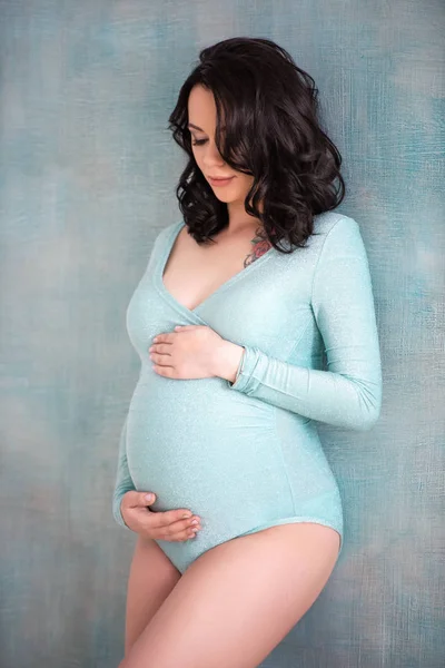 Menina grávida bonita mulher morena em um corpo azul na moda sui — Fotografia de Stock