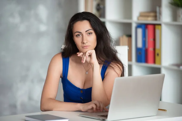 Hermosa diseñadora de mujer de negocios en vestido azul mira en el portátil. Negocio femenino en la oficina —  Fotos de Stock