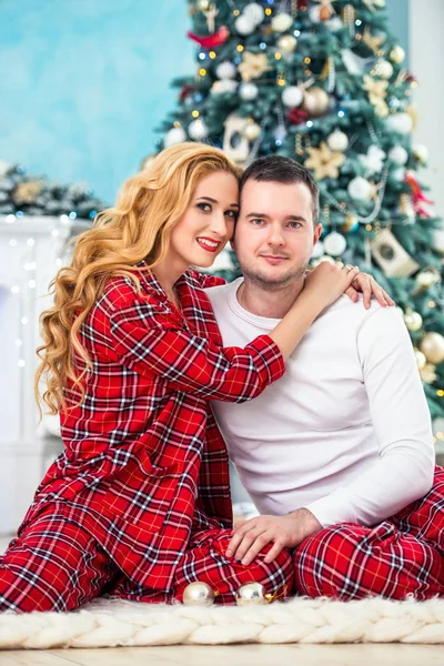Любящие супруги в клетчатой пижаме сидят рядом — стоковое фото