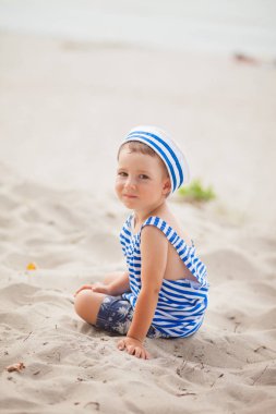 küçük çocuk denizci fanila ve cap deniz plaj, yaz arka plan oturur