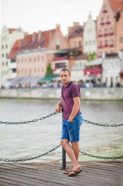 biri Bordo tişört ve kot şort ile zincir çit yakınındaki iskelede