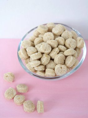 Pembe arka planda cam kasede ezilmiş yulaf ezmesi.