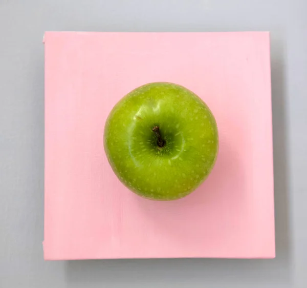 Maturare Mela Verde Quadrato Rosa Uno Sfondo Grigio — Foto Stock