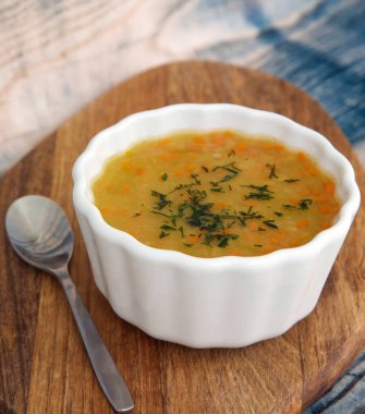 Havuçlu vejetaryen fasulye çorbası ve ahşap tezgahta dereotu.