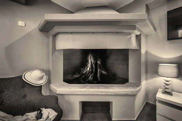 open home fireplace with room light and chair. sepia toning
