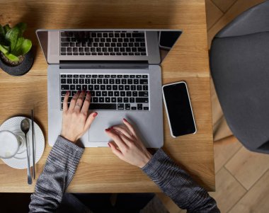 Düz yatıyordu. Businesswoman proje için laptop üzerinde çalışır. Millennial evde ofis içecek kahve defter üzerinde iş arıyor. Modern taşınabilir bilgisayar ve telefon kullanarak tanınmaz kadın