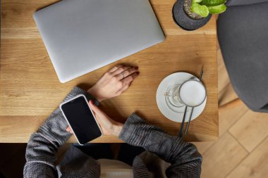 Düz yatıyordu. Businesswoman proje için laptop üzerinde çalışır. Millennial evde ofis içecek kahve defter üzerinde iş arıyor. Modern taşınabilir bilgisayar ve telefon kullanarak tanınmaz kadın