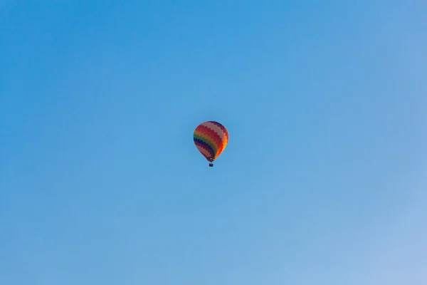 Renkli sıcak hava balonu mavi gökyüzünde uçuyor . 