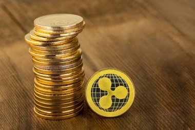 Bir tek altın Ripplecoin dijital sikke üzerinde duran kenar ile birlikte dağıtılmış küresel mali, dijital cryptocurrency, para, online finans ve yatırım kavramı paralar yığılmış yığını