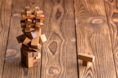 Üç karmaşık hatırlayan ahşap bulmacalar içine bir kule ile tek tek gevşek parça kopya alanı bir ahşap zemin üzerine yığılmış