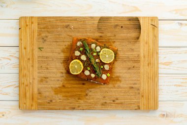 Baharat ve otlar merkezinde ahşap kesme tahtası Beyaz ahşap masanın üstünde tepe-in dilim balık fileto kaplı
