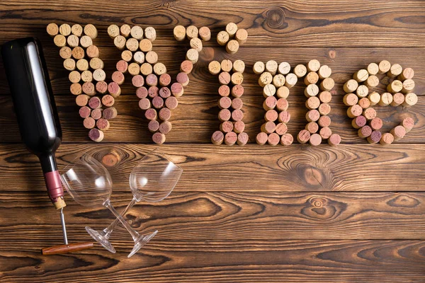 Weinschriftzug Aus Korken Mit Flasche Und Zwei Gläsern Vor Holzhintergrund — Stockfoto