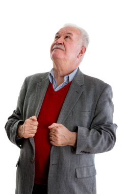 Yaşlı emekli adam ayakta beyaz izole bir ciddi düşünceli ifade ile ararken ceketinin lapels sürükleyici