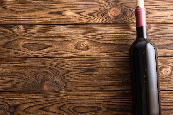 Fles Rode Wijn Liegen Tegen Donkere Houten Achtergrond — Stockfoto