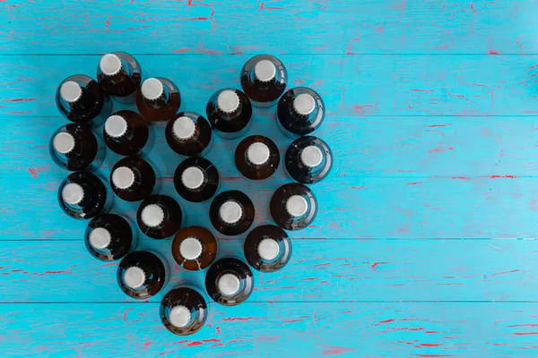 Hjerteformet Stilleben Ølflasker Med Lokk Sett Øverst Blått Piknikbord Konseptuelt – stockfoto