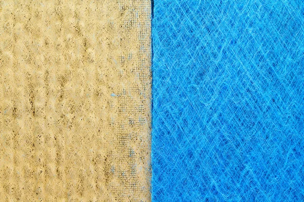 Comparison of clean and dirty dynamic polarised microfibre air filters showing dust entrapped in the fibres carrying an electrostatic charge on the left and clean replacement filter on the right