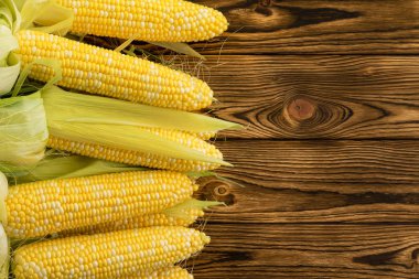 Bir çiftçi pazarda kopya alanı ile ahşap bir masa ekranda sulu taze çekirdekleri ile sağlıklı organik corncobs kenarlığını yan