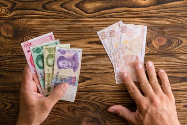 Dış Ticaret ve Döviz Alım Satım, kriz, devalüasyon ve ekonomik politika kavramı Türk Lirası yerine ödemek için Çin Yuan kullanan adam
