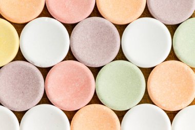 Soluk renkli dairesel vitamin veya ahşap masa yüzeyi üzerine oturan tablet görünümünü kapat