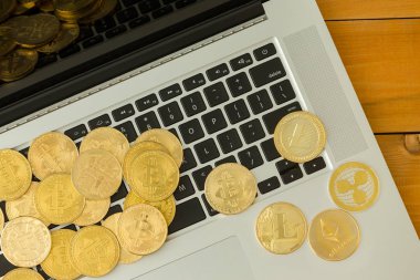 Altın sikke, cryptocurrencies, Bitcoin, Ethereum ve Litecoin, laptop klavye, yakın çekim yukarıdan izlendi üzerinde dağınık