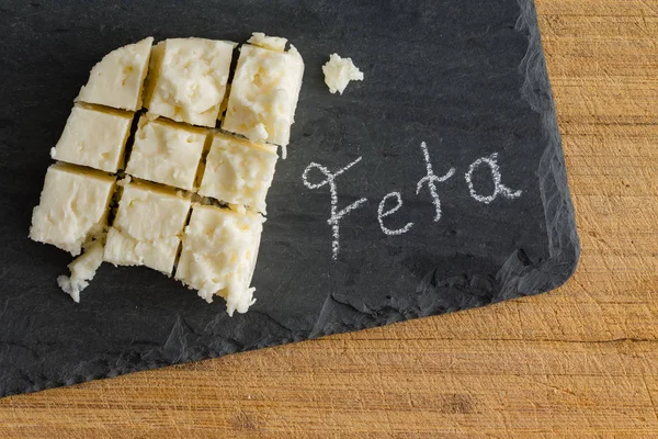 손으로 텍스트 슬레이트 보드에 전통적인 소프트 그리스어 Feta 치즈의 절단된 — 스톡 사진