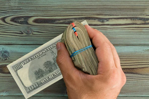 Mannenhand Houdt Een Gevouwen Bundel Van Biljetten Van 100 Dollar — Stockfoto