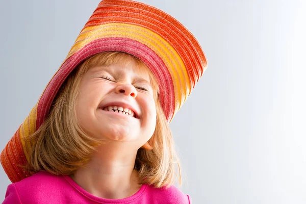 Junges Mädchen Mit Buntem Hut Das Gesicht Zusammengekniffen Lachend Oder — Stockfoto