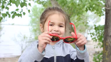 Kız açık havada güneş gözlüğü üzerinde koyar