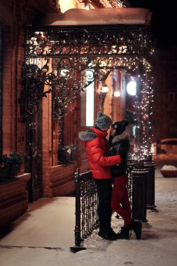 Building yakınındaki geceleri ayakta sevgi dolu çift kucaklayan Noel çelenk ile dekore edilmiştir. Kış, Sevgililer günü, yeni yıl, yılbaşı